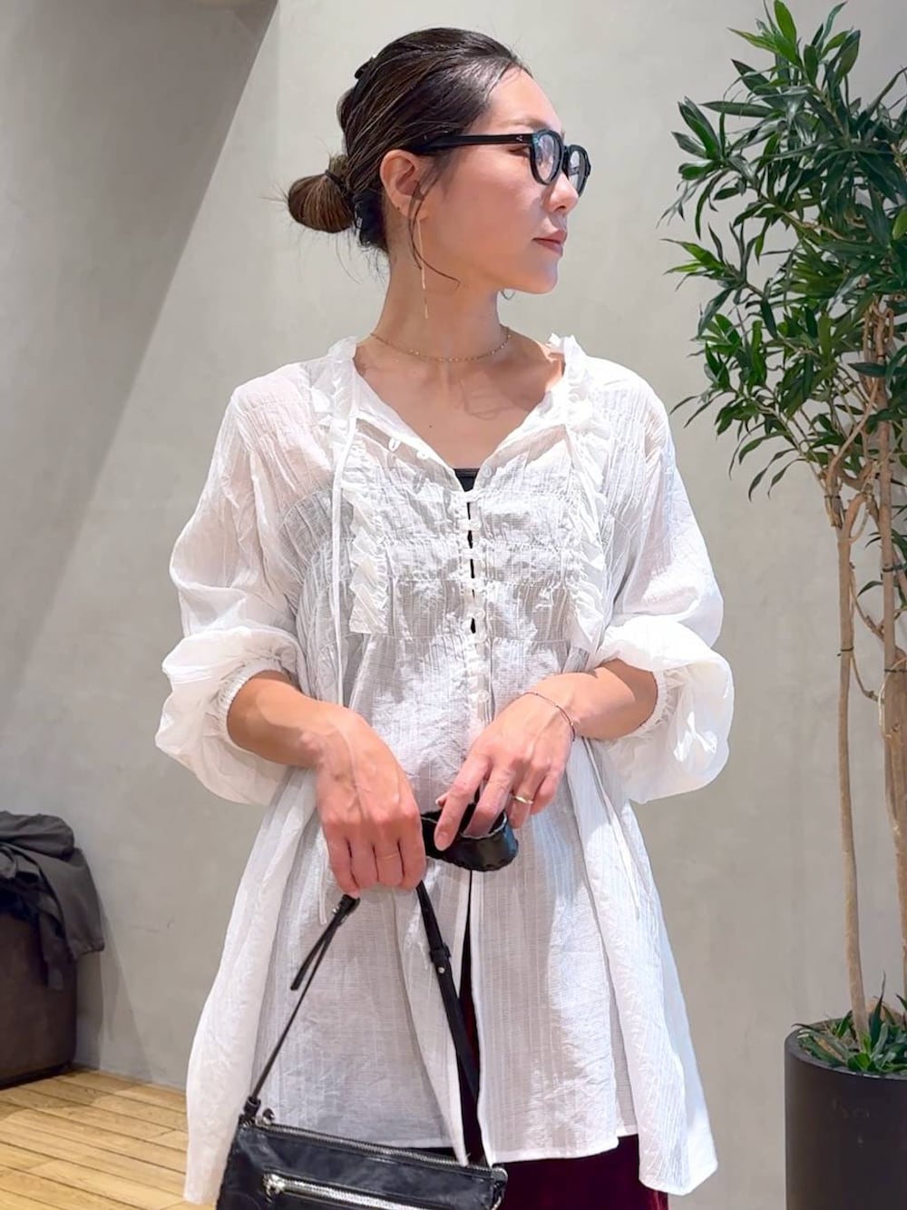 ブラウン系のローファー、ホワイト系のチュニック、レッド系のデニムパンツを着用したレディースの秋コーディネートの7枚目の写真