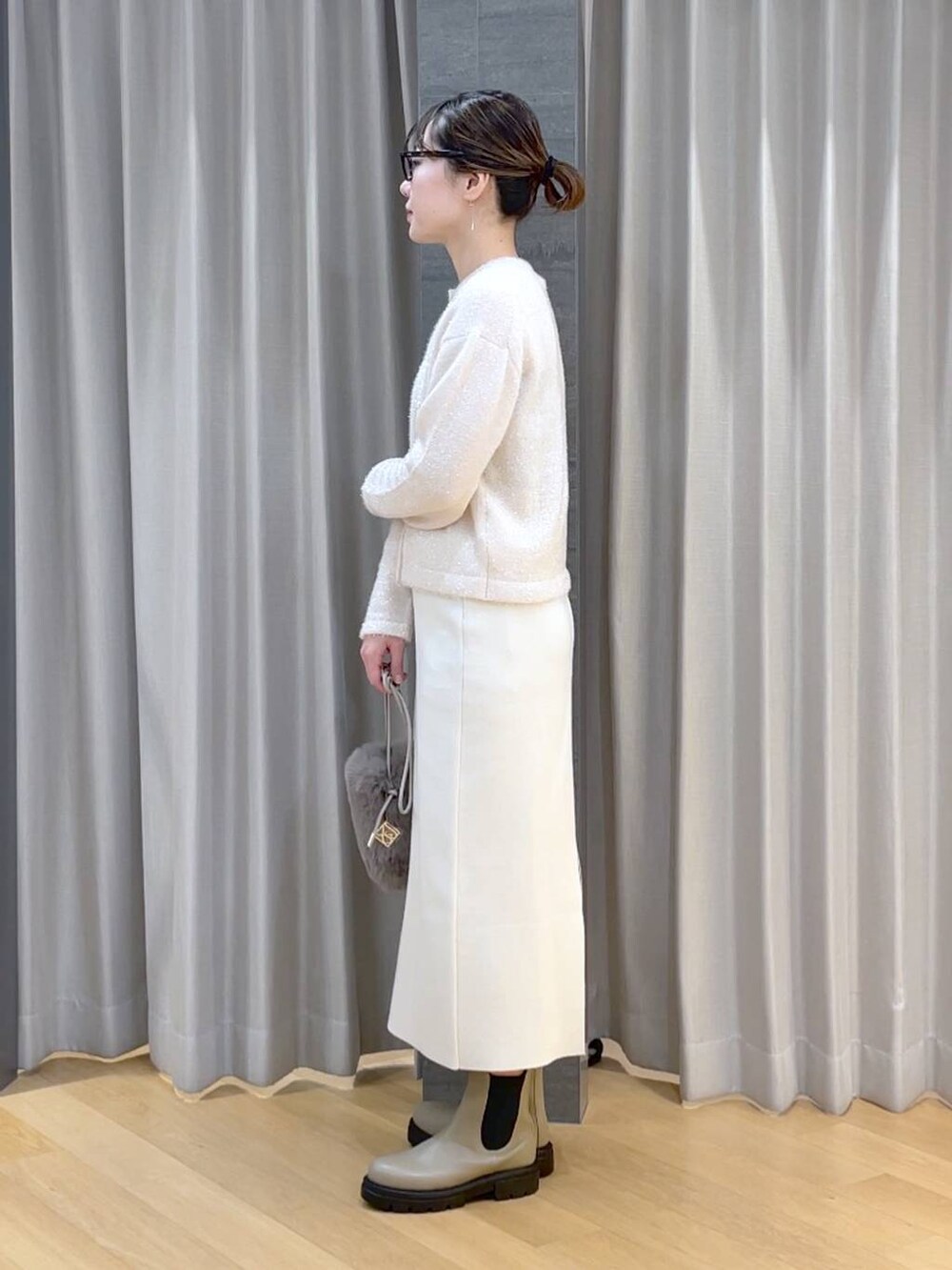 ベージュ系のブーツ、ホワイト系のニット/セーター、ベージュ系のショルダーバッグを着用したレディースの冬コーディネートの3枚目の写真