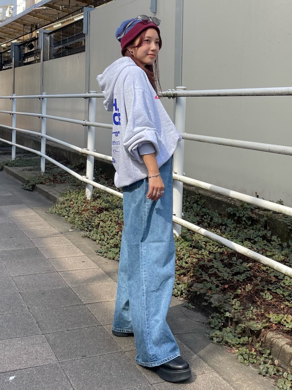 ホワイト系のパーカー、ブルー系のデニムパンツ、レッド系のニットキャップ/ビーニーを着用したレディースの秋コーディネートの2枚目の写真