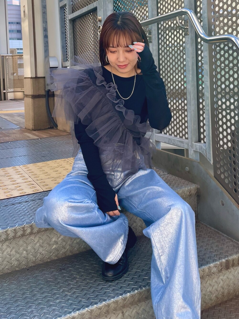 ブラック系のTシャツ/カットソー、グレー系のベスト、シルバー系のデニムパンツを着用したレディースの冬コーディネートの5枚目の写真