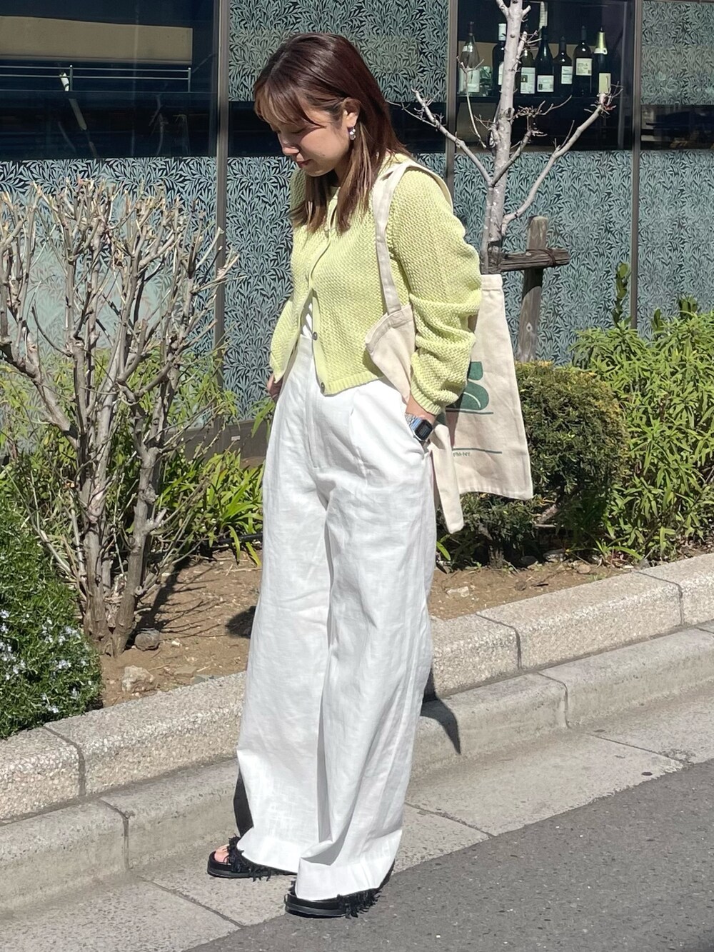 グリーン系のカーディガン/ボレロ、ホワイト系のその他パンツ、グリーン系のトートバッグを着用したレディースの春コーディネートの2枚目の写真