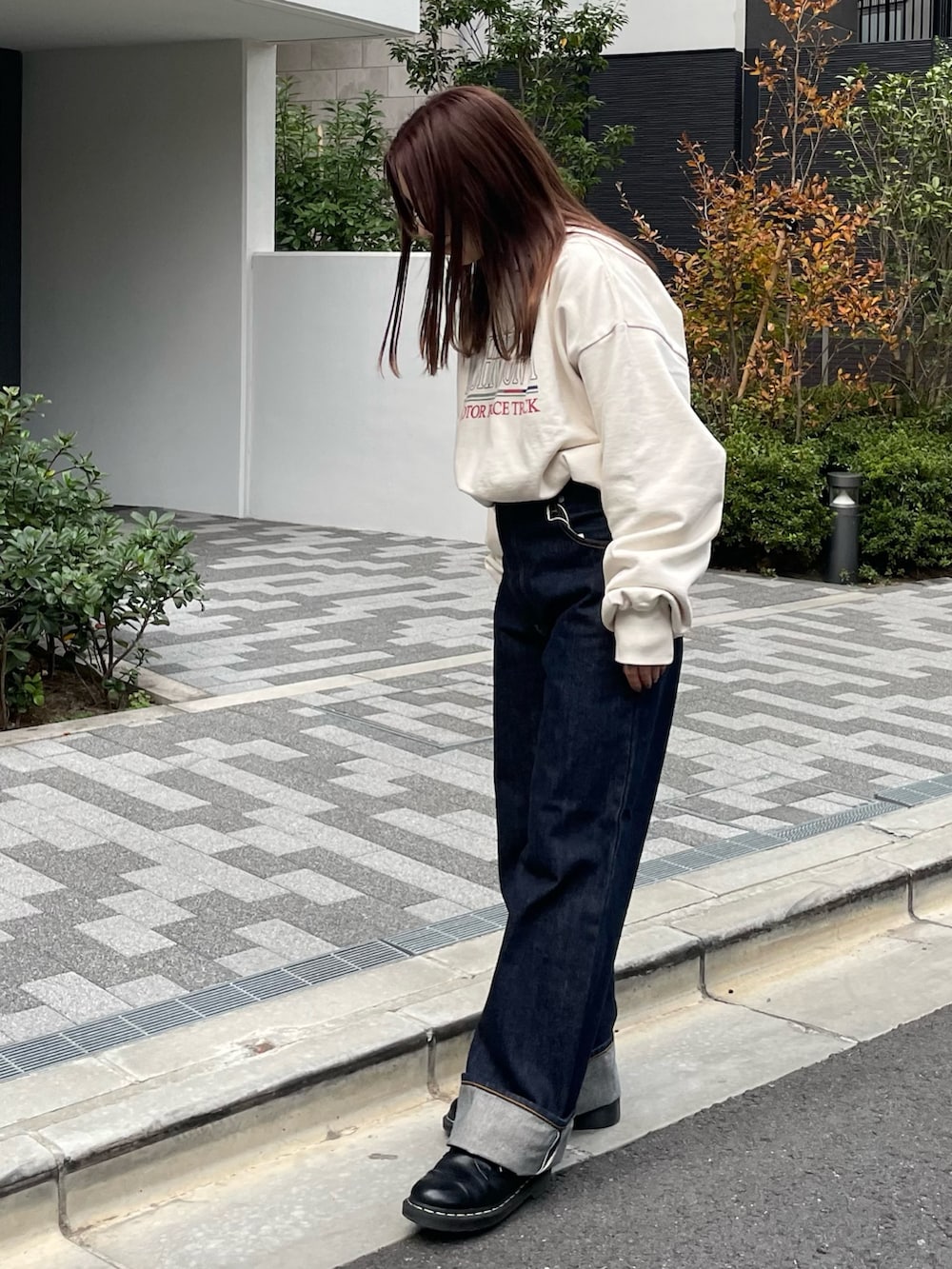 ホワイト系のスウェット、ブルー系のデニムパンツを着用したレディースの冬コーディネートの2枚目の写真