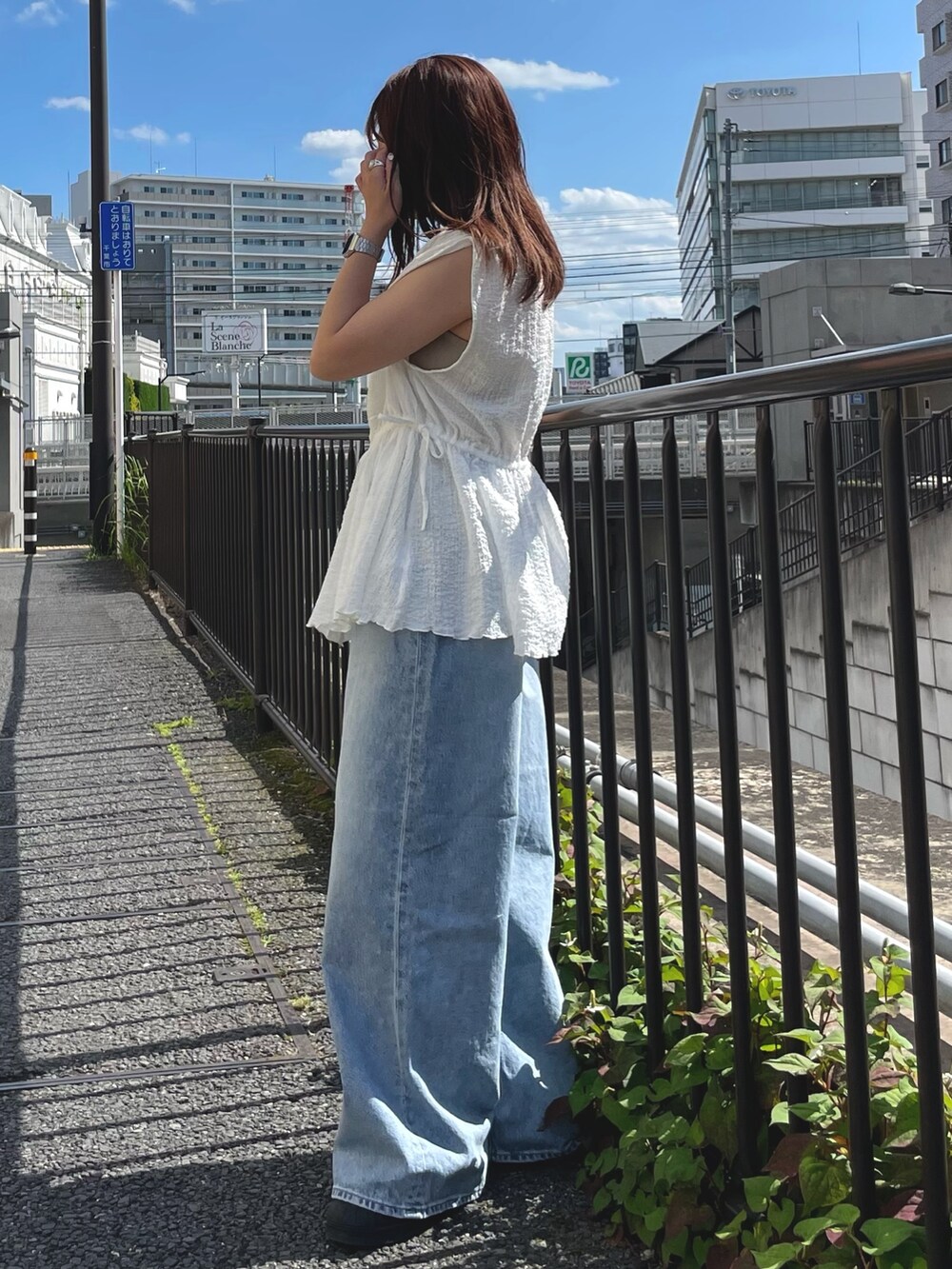ホワイト系のシャツ/ブラウス、ブルー系のデニムパンツを着用したレディースの夏コーディネートの2枚目の写真