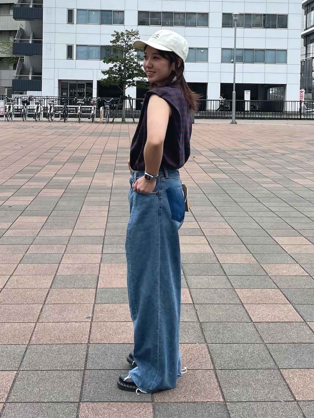 ブラウン系のTシャツ/カットソー、ブルー系のデニムパンツ、ホワイト系のキャップを着用したレディースの春コーディネートの2枚目の写真
