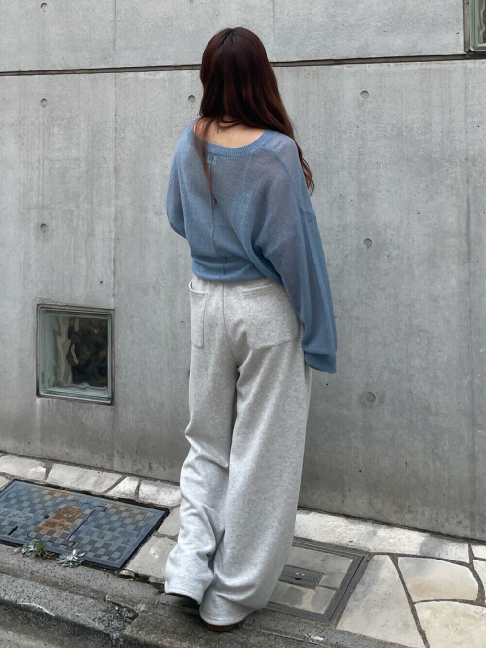 ブルー系のニット/セーター、グレー系のスウェットパンツ、ブラウン系のスニーカーを着用したレディースの秋コーディネートの3枚目の写真