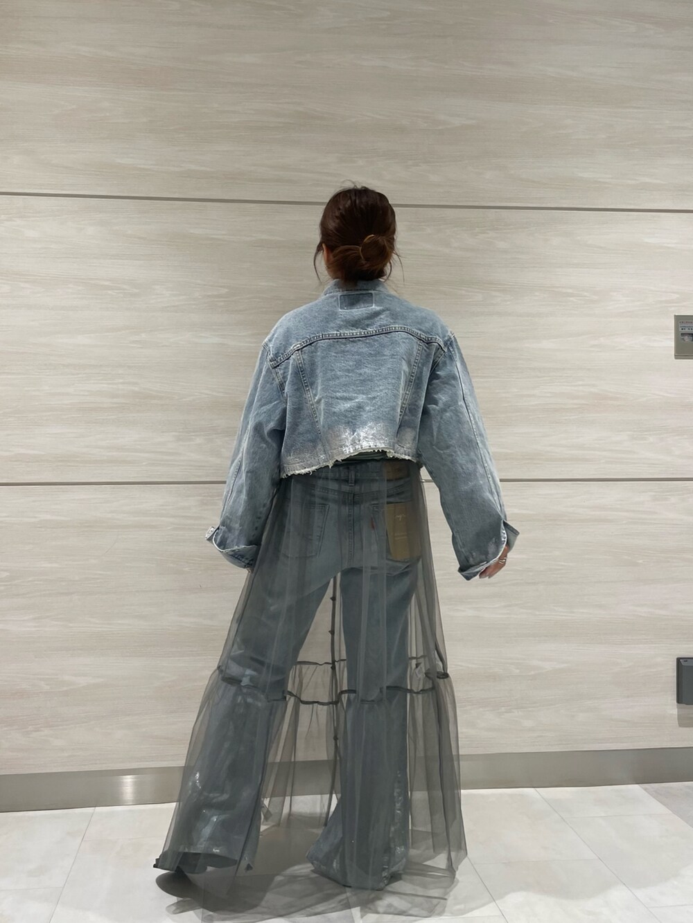 ブルー系のデニムジャケット、ブルー系のデニムパンツ、グレー系のワンピースを着用したレディースの夏コーディネートの2枚目の写真