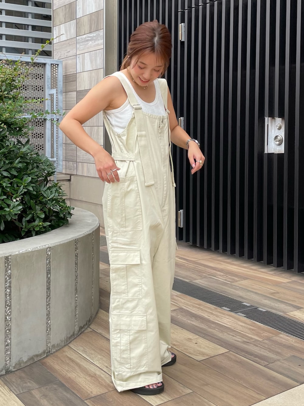 ベージュ系のサロペット/オーバーオール、ホワイト系のTシャツ/カットソーを着用したレディースの夏コーディネートの4枚目の写真