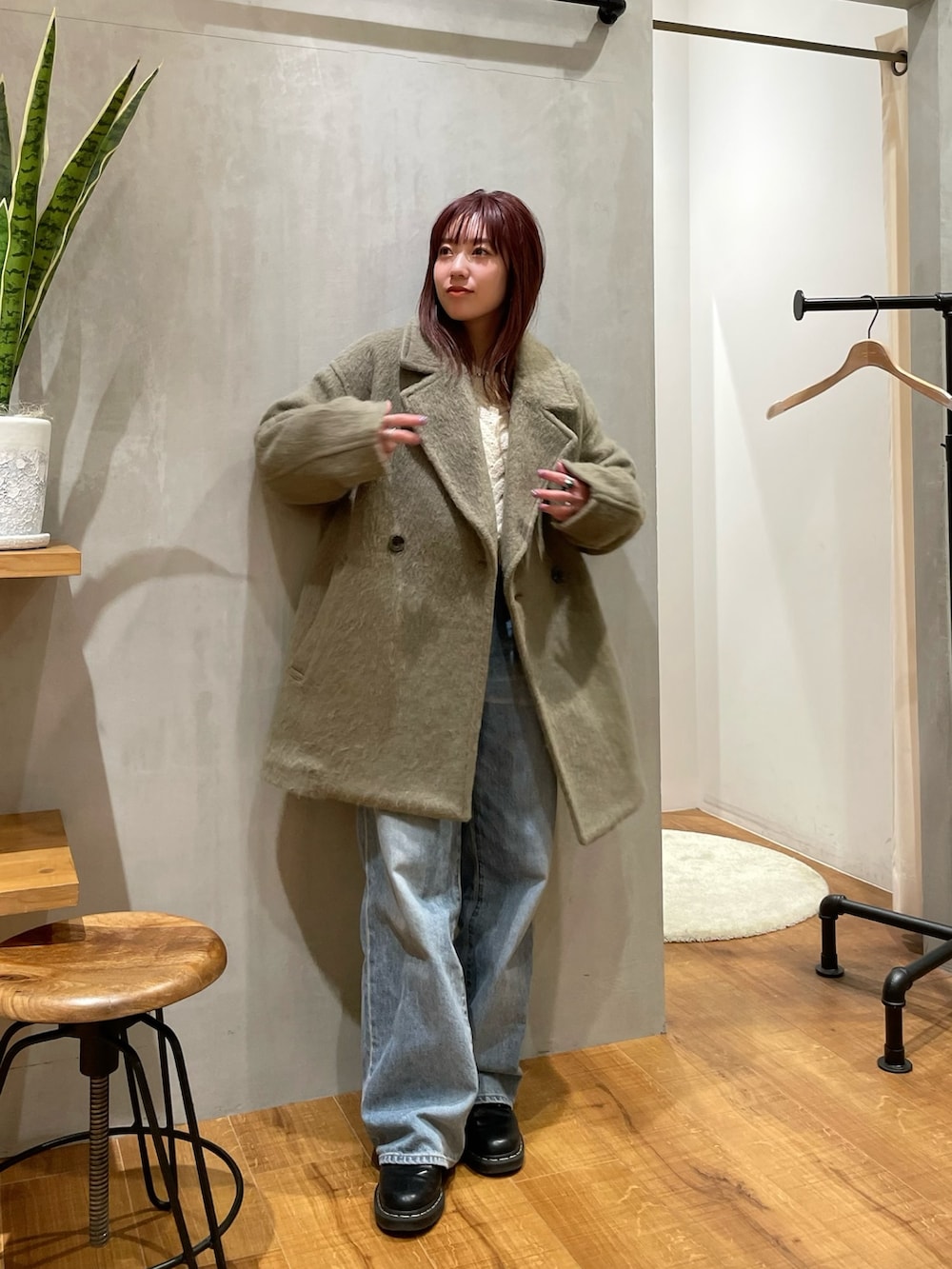 グリーン系のピーコートを着用したレディースの冬コーディネートの2枚目の写真