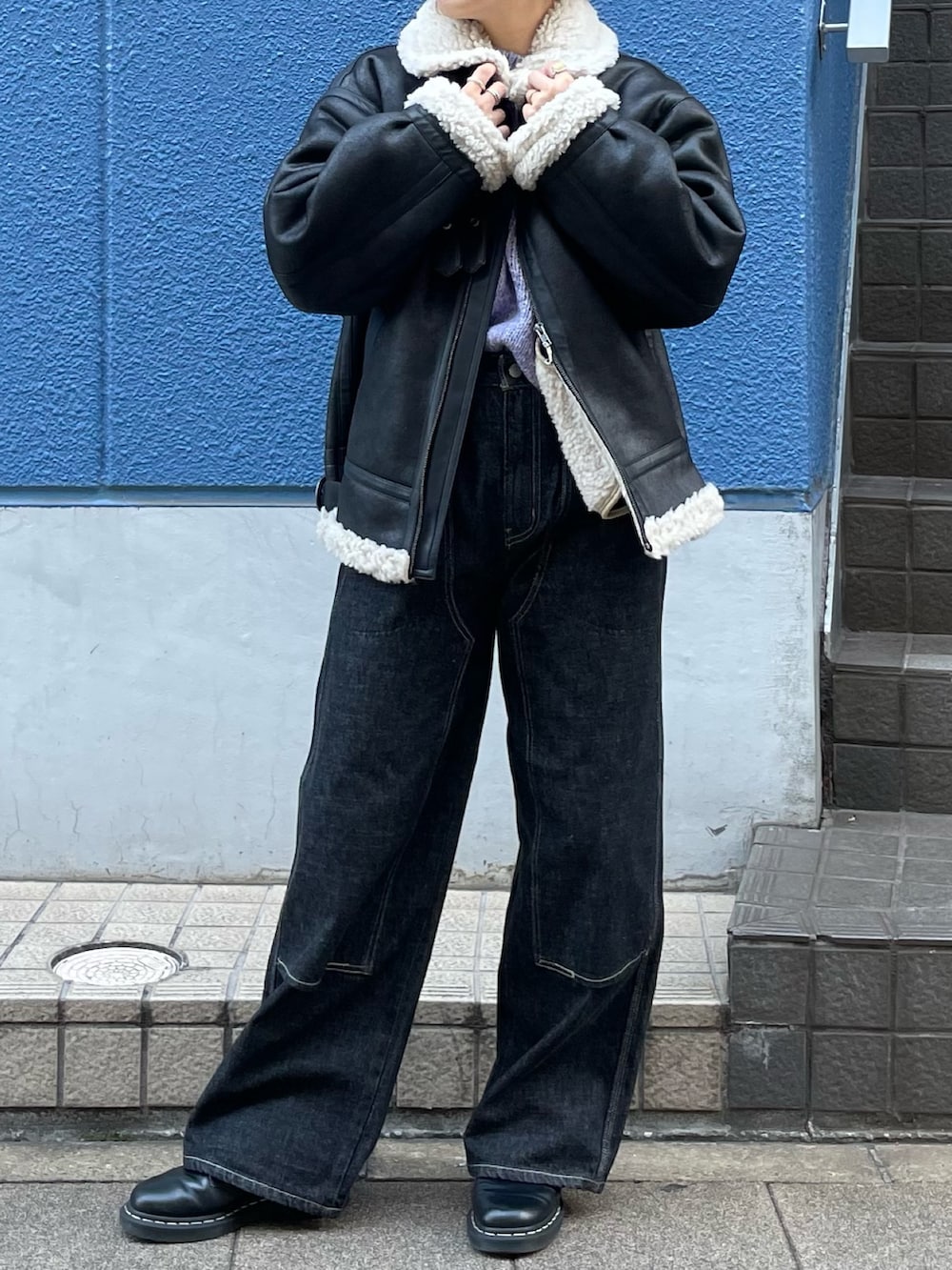 ブラック系のブルゾン、ブラック系のデニムパンツを着用したレディースの秋コーディネートの4枚目の写真