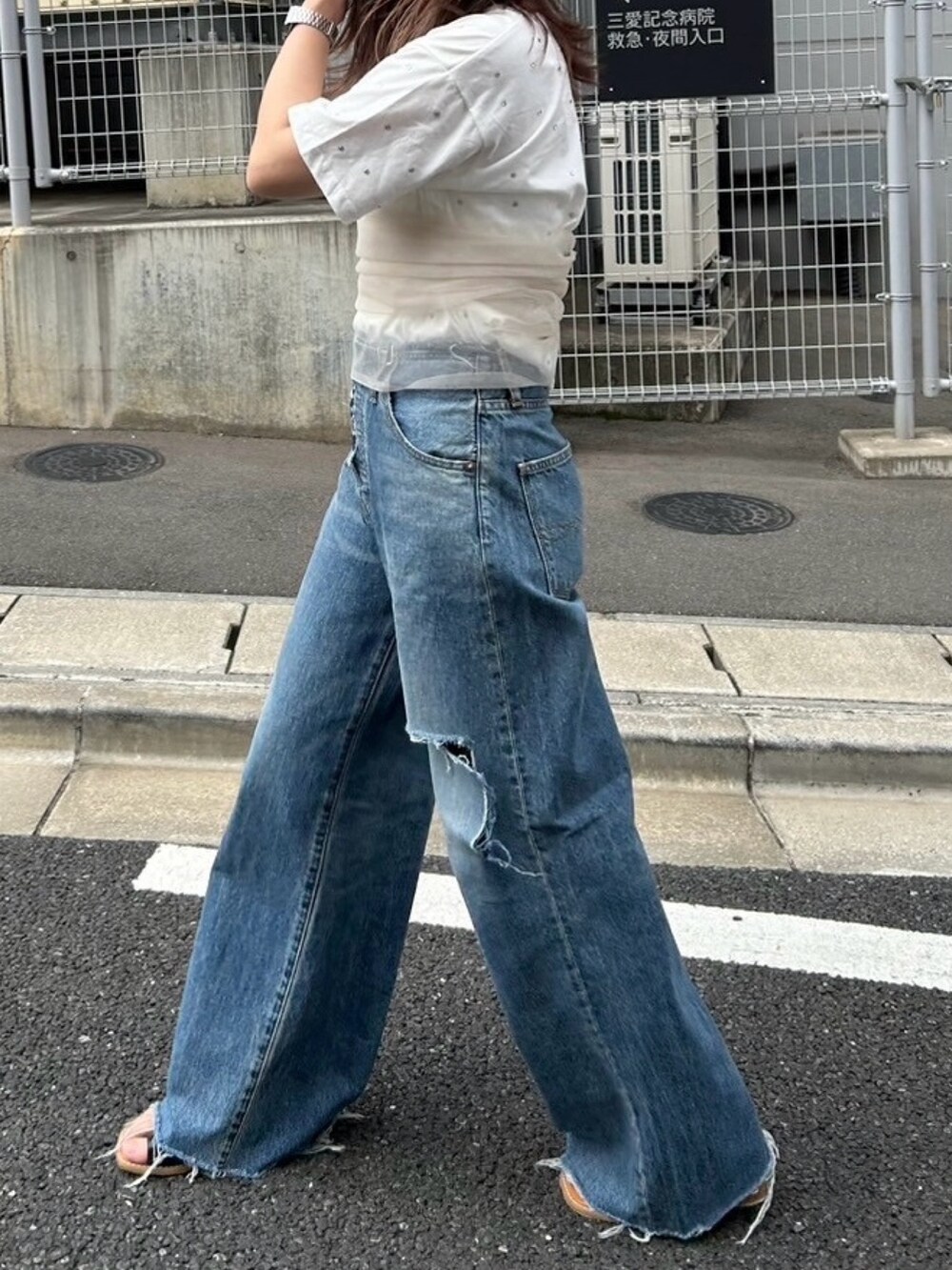 ホワイト系のTシャツ/カットソー、ベージュ系のキャミソール、ブルー系のデニムパンツを着用したレディースの春コーディネートの4枚目の写真