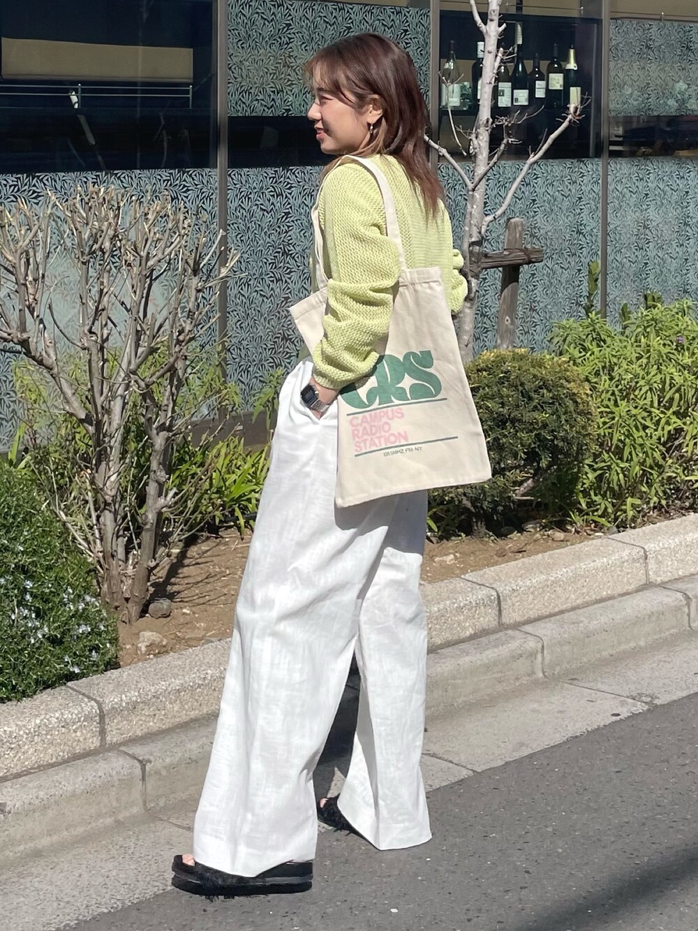 グリーン系のカーディガン/ボレロ、ホワイト系のその他パンツ、グリーン系のトートバッグを着用したレディースの春コーディネートの4枚目の写真