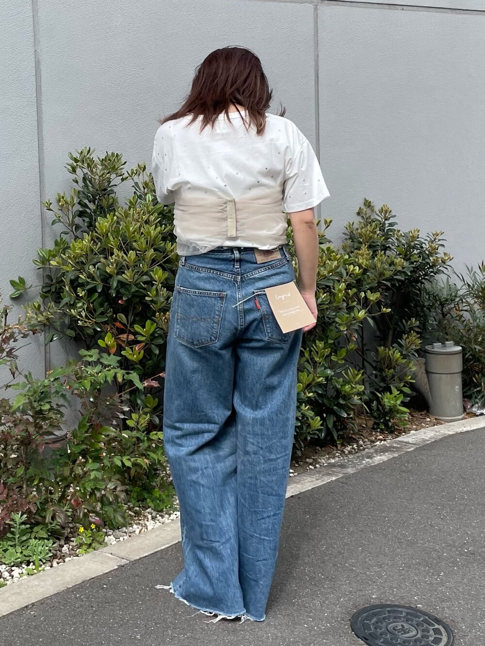 ホワイト系のTシャツ/カットソー、ベージュ系のキャミソール、ブルー系のデニムパンツを着用したレディースの春コーディネートの3枚目の写真