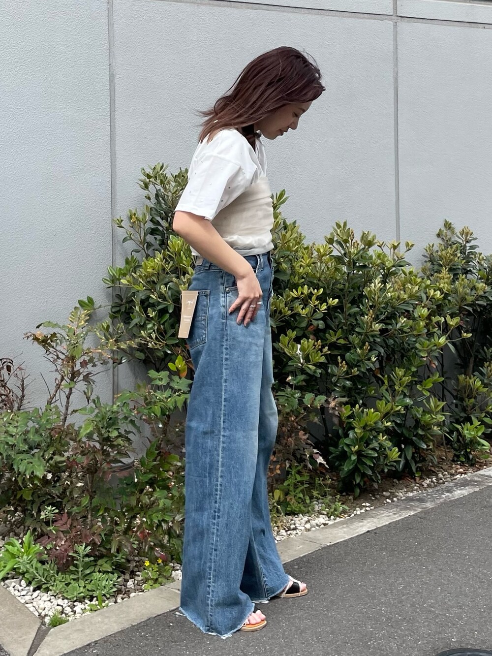 ホワイト系のTシャツ/カットソー、ベージュ系のキャミソール、ブルー系のデニムパンツを着用したレディースの春コーディネートの2枚目の写真