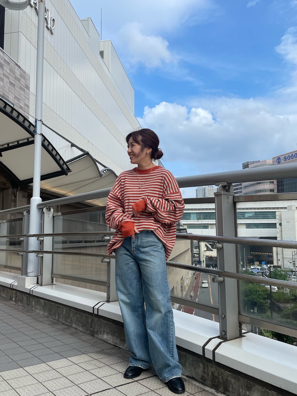 オレンジ系のTシャツ/カットソー、ブラック系のローファー、ブルー系のデニムパンツを着用したレディースの夏コーディネートの2枚目の写真