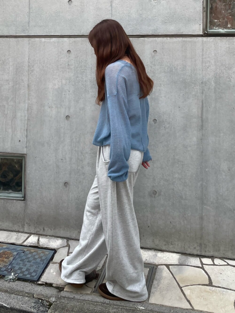 ブルー系のニット/セーター、グレー系のスウェットパンツ、ブラウン系のスニーカーを着用したレディースの秋コーディネートの2枚目の写真