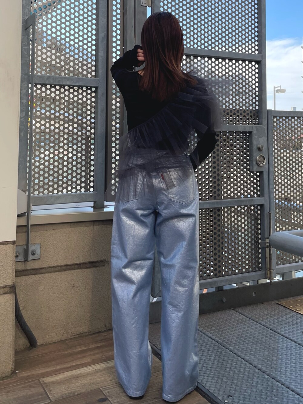 ブラック系のTシャツ/カットソー、グレー系のベスト、シルバー系のデニムパンツを着用したレディースの冬コーディネートの2枚目の写真