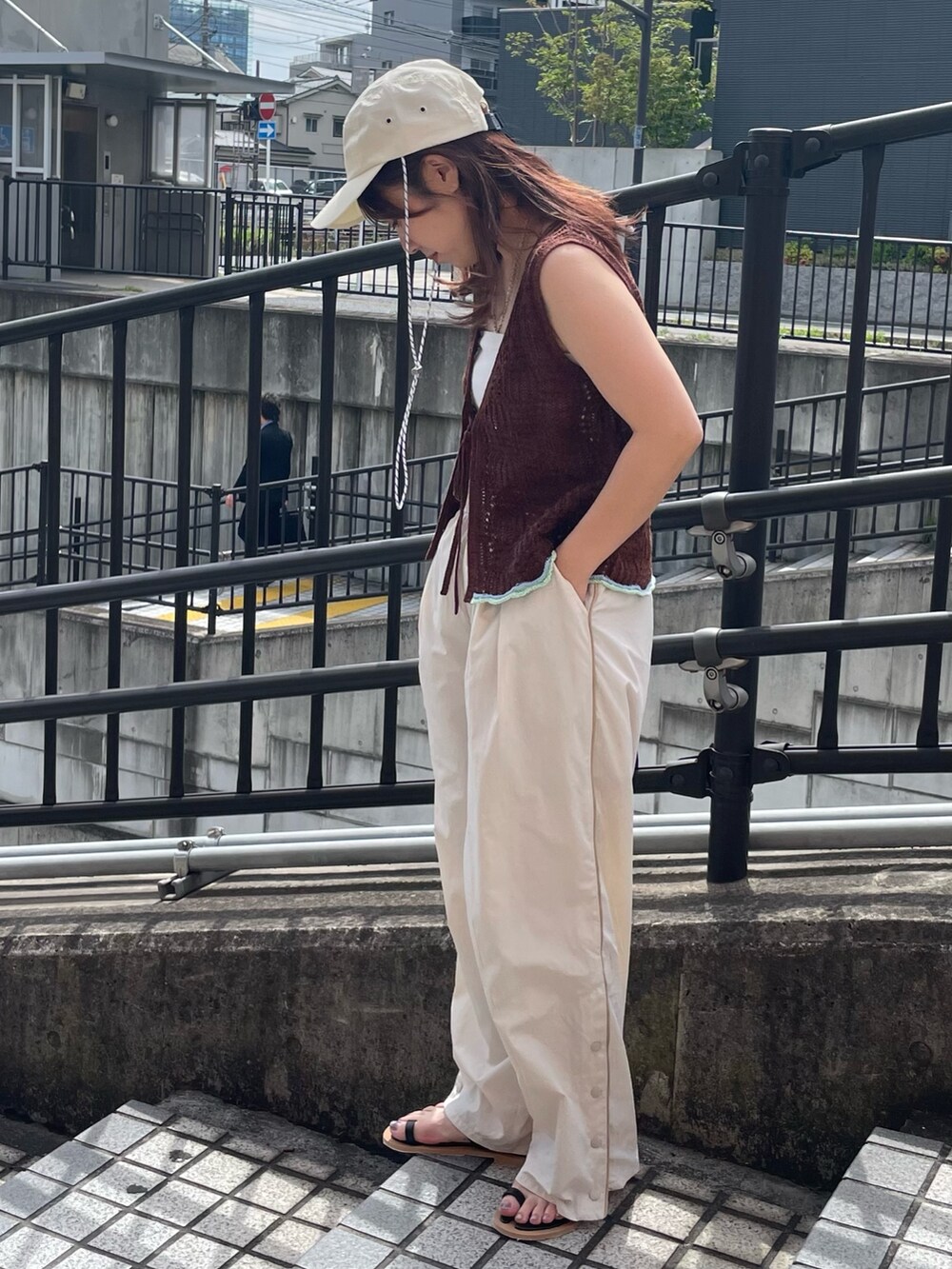 ブラウン系のニット/セーター、ホワイト系のその他パンツ、ブラック系のサンダルを着用したレディースの春コーディネートの2枚目の写真