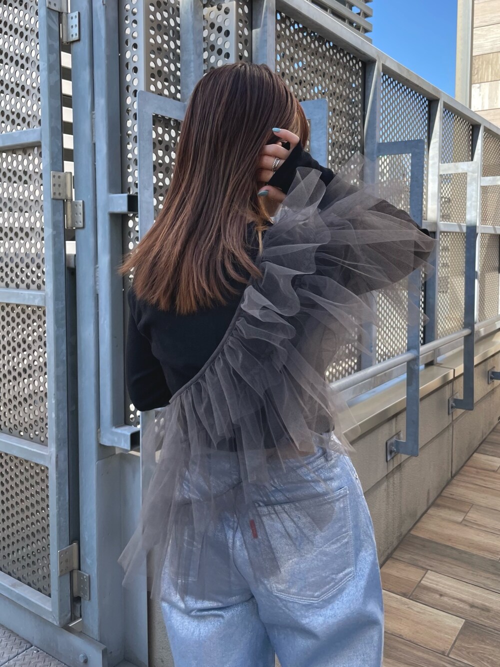 ブラック系のTシャツ/カットソー、グレー系のベスト、シルバー系のデニムパンツを着用したレディースの冬コーディネートの3枚目の写真