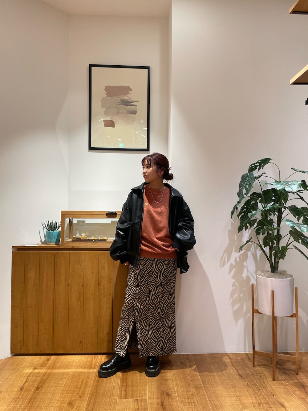 ブラック系のブルゾン、オレンジ系のスウェット、ブラウン系のスカートを着用したレディースの秋コーディネートの2枚目の写真