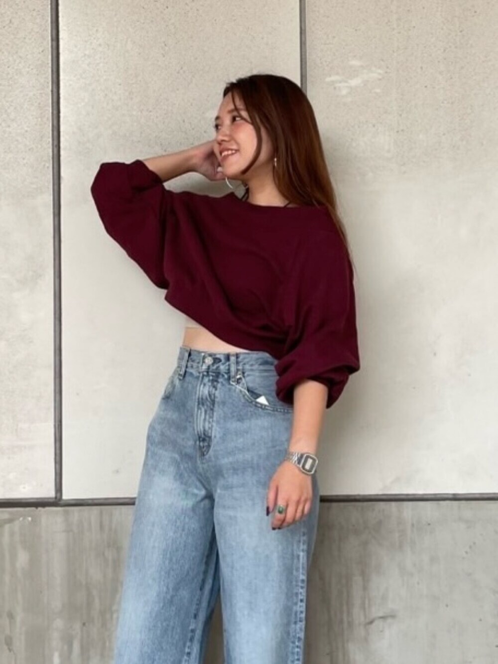 レッド系のスウェット、ブルー系のデニムパンツを着用したレディースの秋コーディネートの4枚目の写真