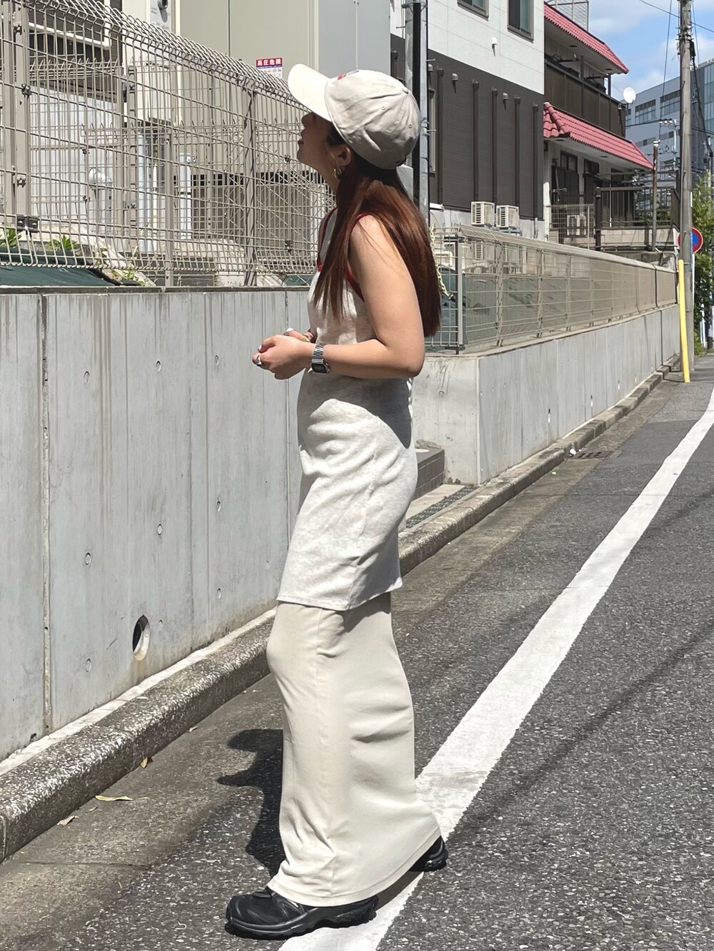 ホワイト系のワンピース、ベージュ系のキャップを着用したレディースの春コーディネートの2枚目の写真