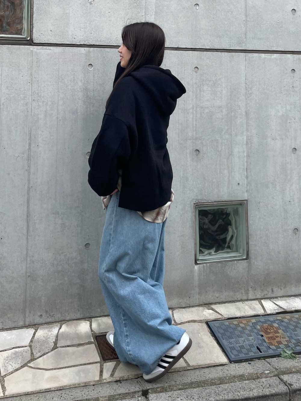 ブラック系のパーカー、ブラウン系のシャツ/ブラウス、ブルー系のデニムパンツを着用したレディースの秋コーディネートの2枚目の写真