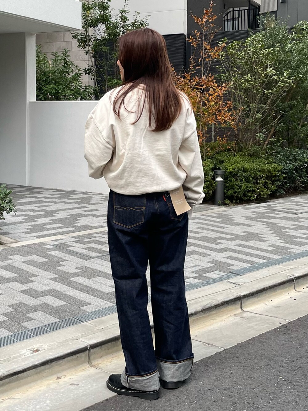 ホワイト系のスウェット、ブルー系のデニムパンツを着用したレディースの冬コーディネートの4枚目の写真