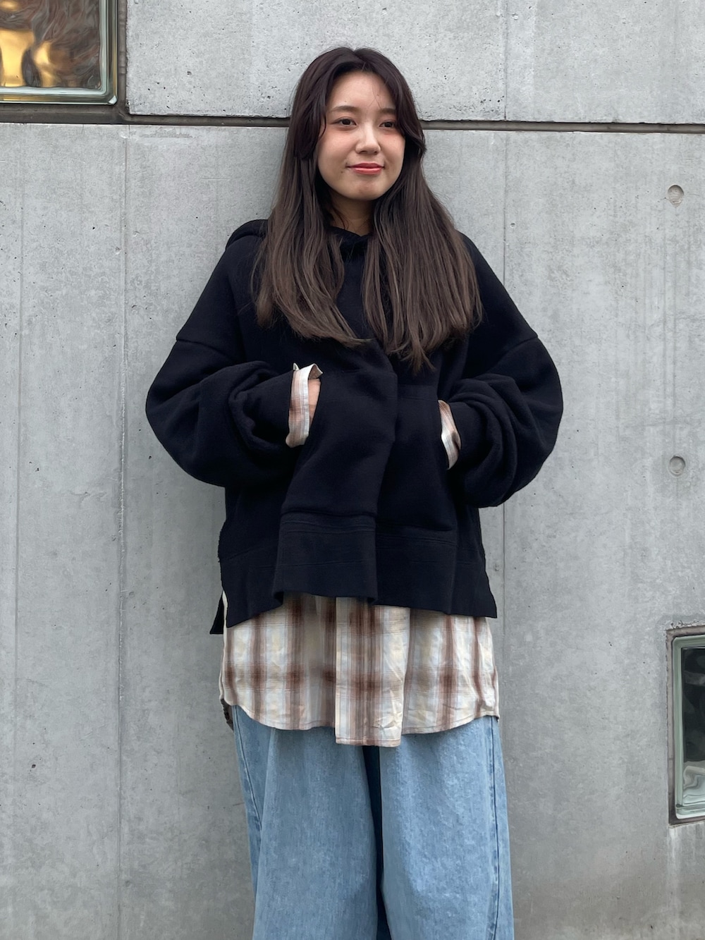 ブラック系のパーカー、ブラウン系のシャツ/ブラウス、ブルー系のデニムパンツを着用したレディースの秋コーディネートの4枚目の写真