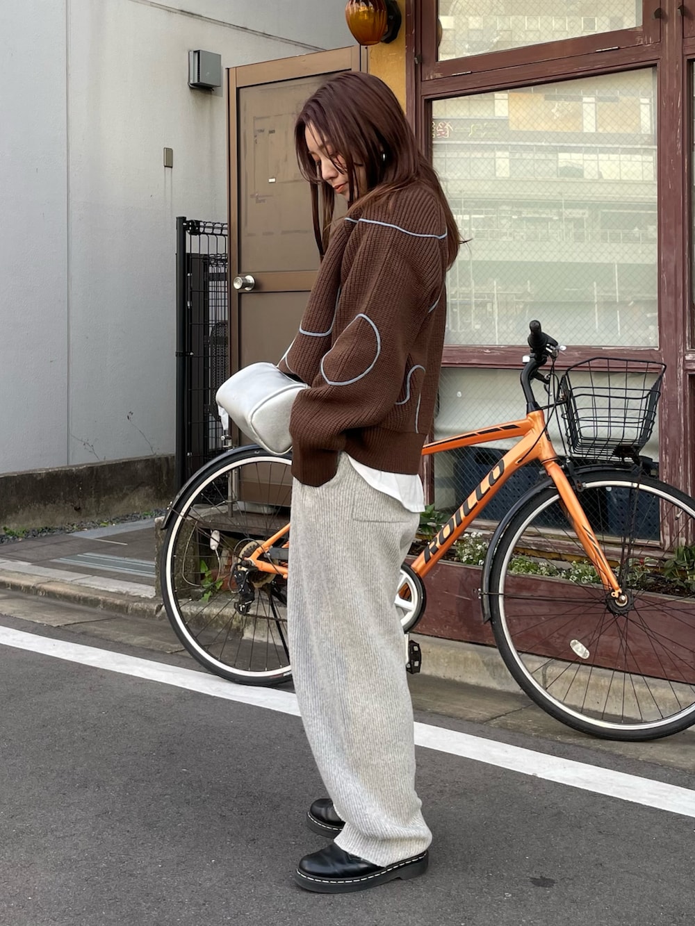 ブラウン系のニット/セーター、グレー系のその他パンツ、ホワイト系のTシャツ/カットソーを着用したレディースの冬コーディネートの2枚目の写真