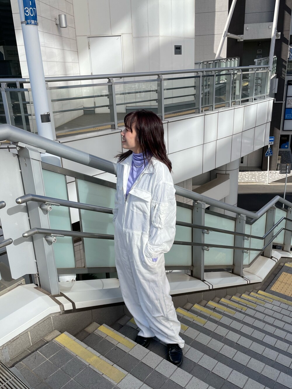 パープル系のTシャツ/カットソー、ホワイト系のつなぎ/オールインワン、グレー系のチェスターコートを着用したレディースの冬コーディネートの5枚目の写真