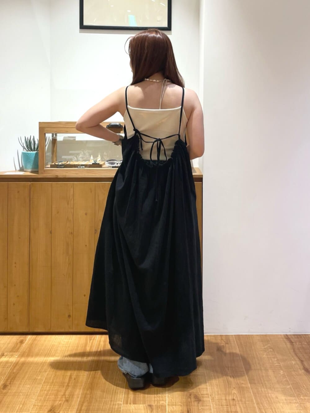 ブルー系のデニムパンツ、ブラック系のワンピース、ホワイト系のキャミソールを着用したレディースの夏コーディネートの3枚目の写真