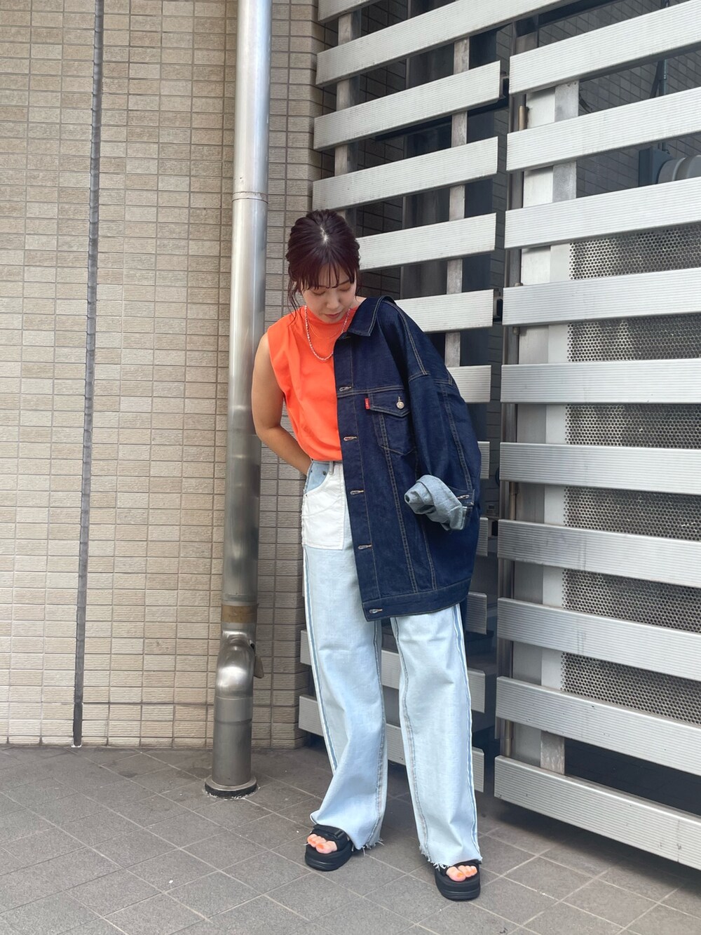 オレンジ系のTシャツ/カットソー、オレンジ系のワンピース、ブルー系のデニムパンツを着用したレディースの夏コーディネートの2枚目の写真
