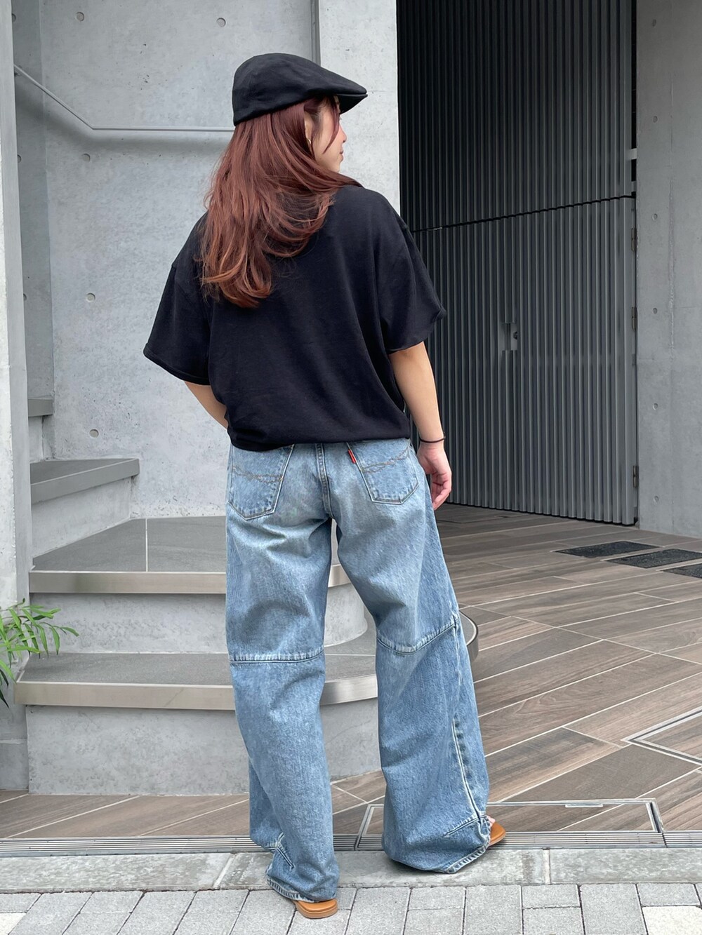 ブラック系のTシャツ/カットソー、ブルー系のデニムパンツ、ブラック系のハンチング/ベレー帽を着用したレディースの夏コーディネートの3枚目の写真