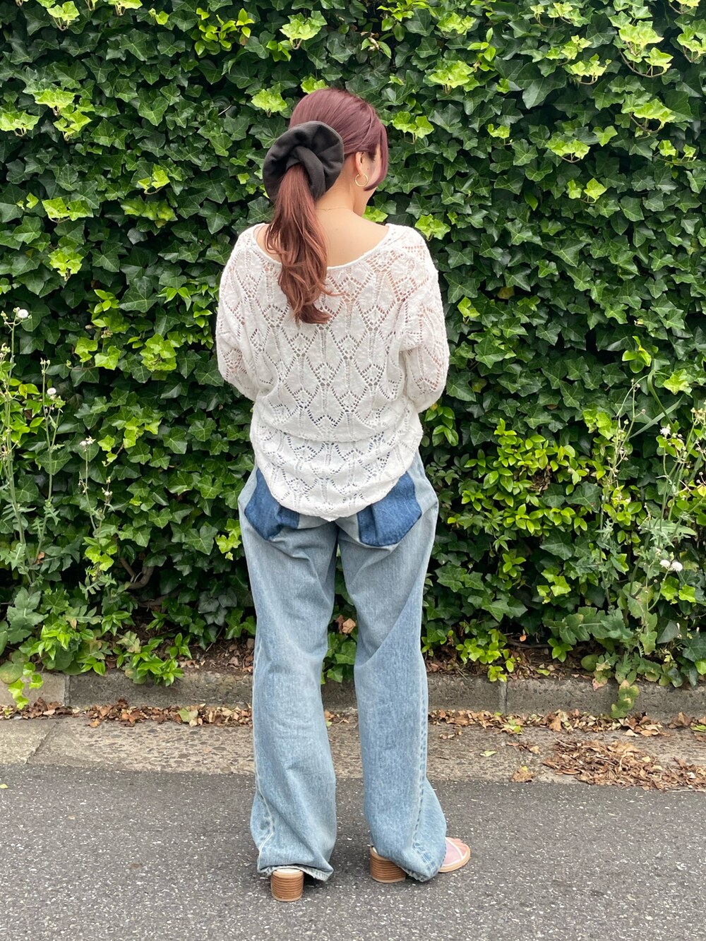 ホワイト系のニット/セーター、ブルー系のデニムパンツ、ホワイト系のサンダルを着用したレディースの夏コーディネートの3枚目の写真
