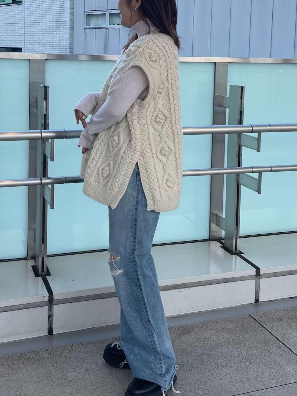 ホワイト系のニット/セーター、ホワイト系のニット/セーター、ブルー系のデニムパンツを着用したレディースの秋コーディネートの3枚目の写真