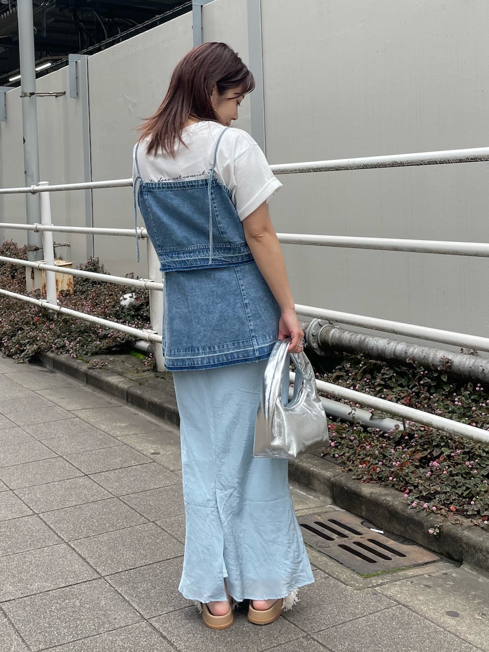 ホワイト系のTシャツ/カットソー、ブルー系のキャミソール、シルバー系のハンドバッグを着用したレディースの春コーディネートの5枚目の写真