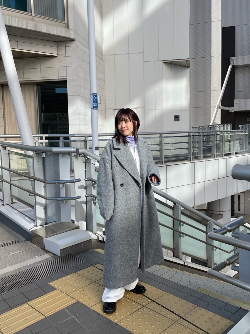 パープル系のTシャツ/カットソー、ホワイト系のつなぎ/オールインワン、グレー系のチェスターコートを着用したレディースの冬コーディネートの3枚目の写真