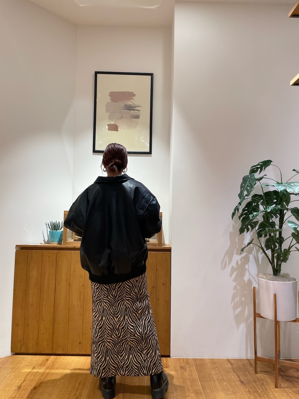 ブラック系のブルゾン、オレンジ系のスウェット、ブラウン系のスカートを着用したレディースの秋コーディネートの3枚目の写真