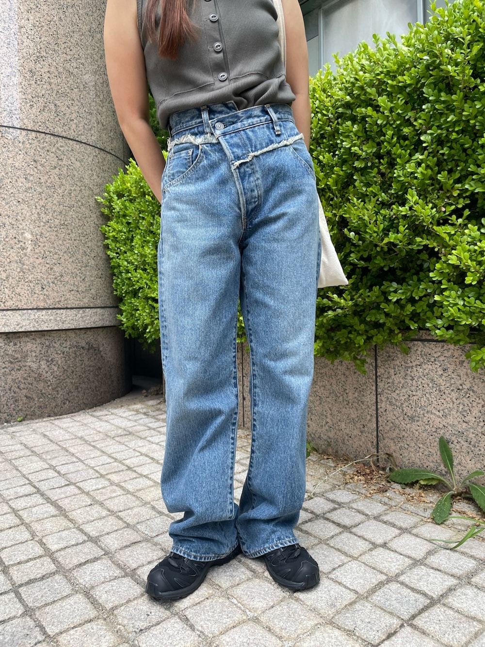 グレー系のタンクトップ、ブルー系のデニムパンツを着用したレディースの夏コーディネートの4枚目の写真
