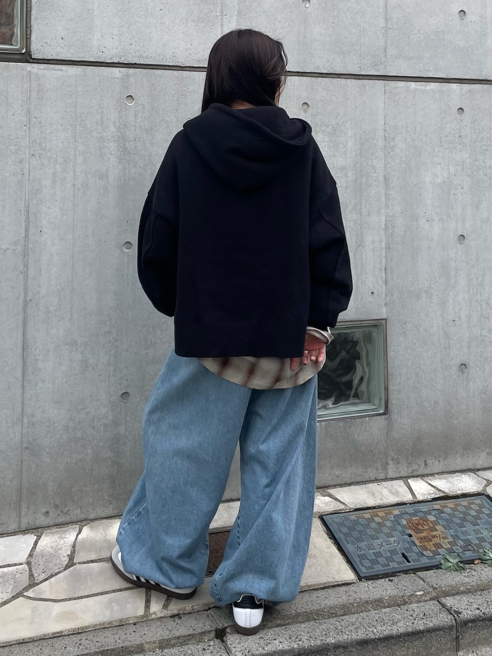 ブラック系のパーカー、ブラウン系のシャツ/ブラウス、ブルー系のデニムパンツを着用したレディースの秋コーディネートの3枚目の写真