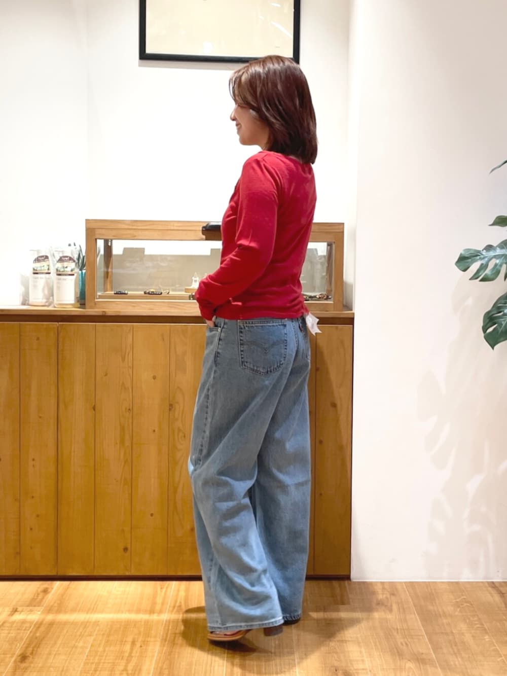 ブルー系のデニムパンツ、その他のサンダル、レッド系のカーディガン/ボレロを着用したレディースの夏コーディネートの2枚目の写真