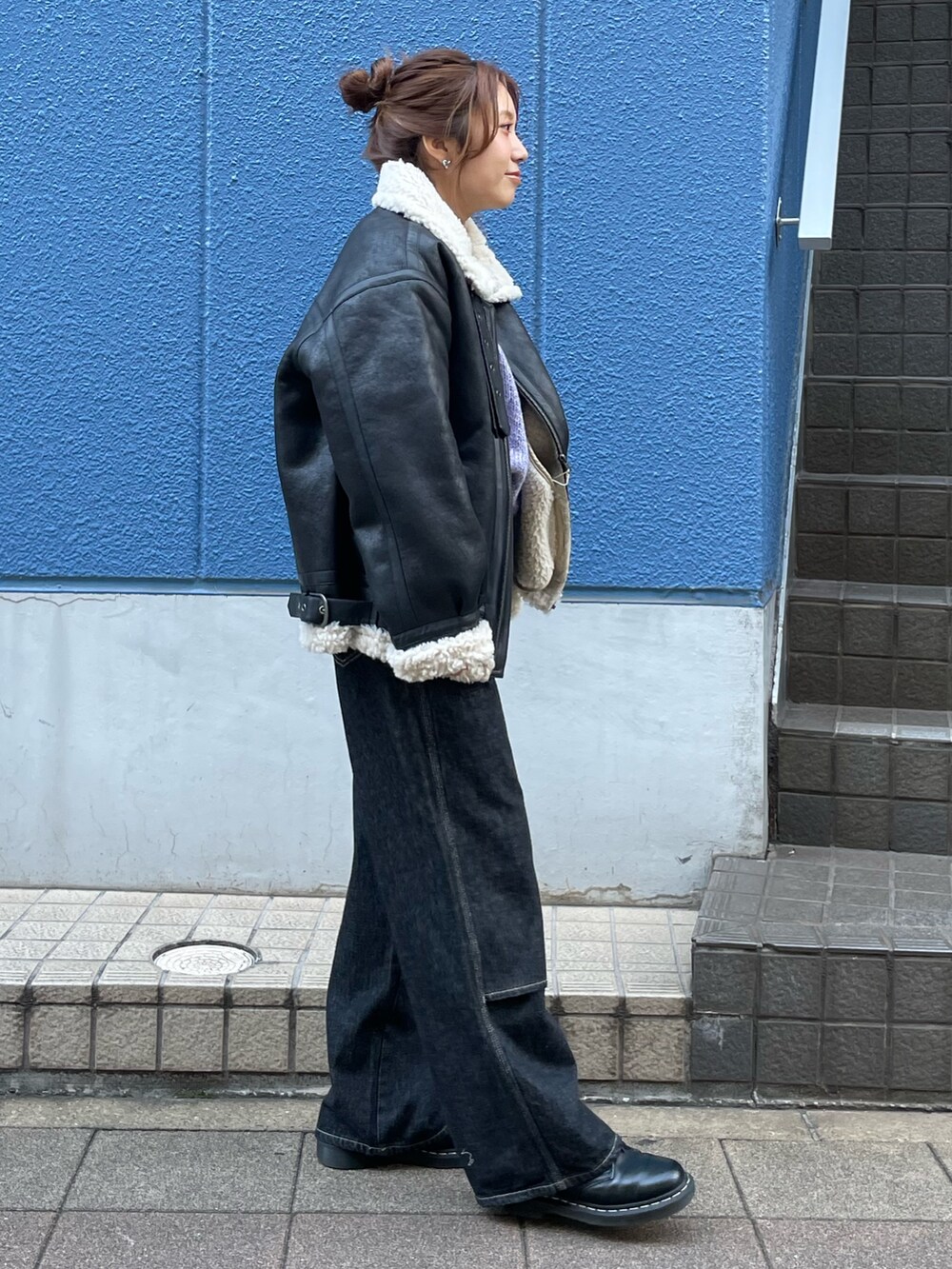 ブラック系のブルゾン、ブラック系のデニムパンツを着用したレディースの秋コーディネートの2枚目の写真