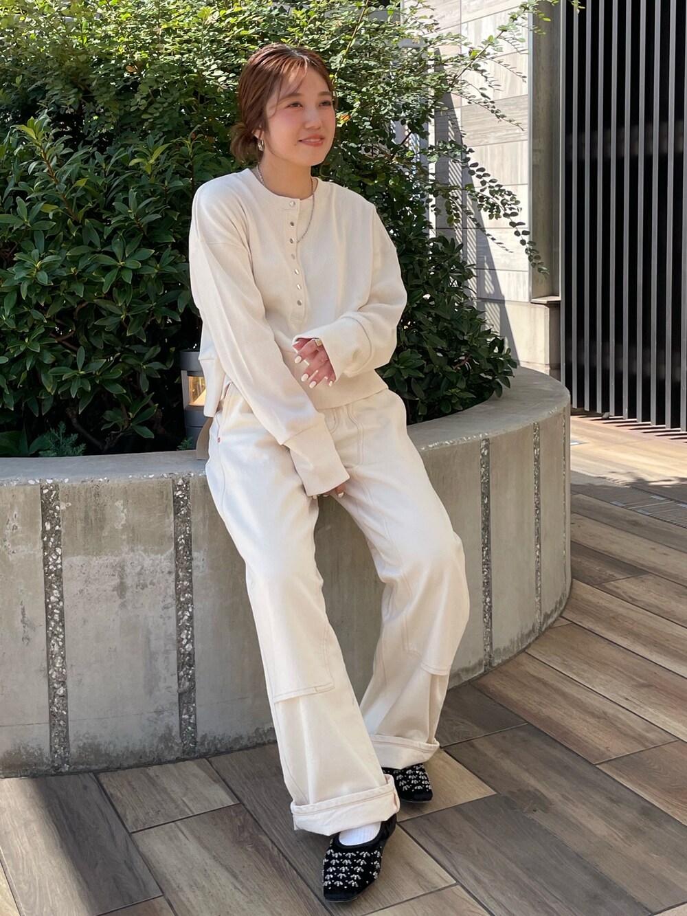 ホワイト系のTシャツ/カットソー、ホワイト系のデニムパンツ、ブラック系のパンプスを着用したレディースの秋コーディネートの5枚目の写真