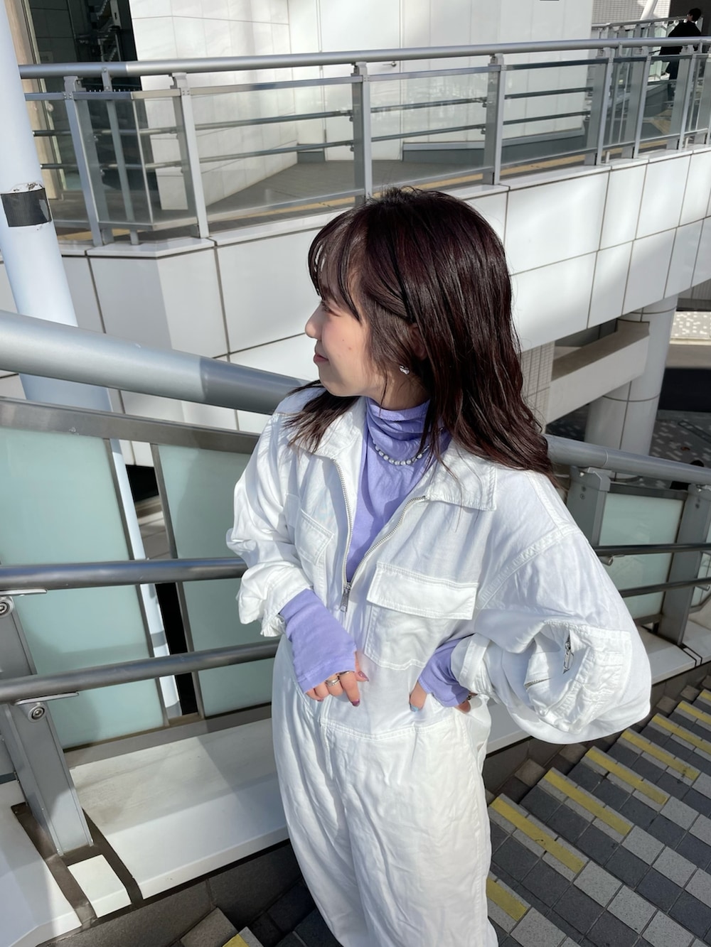 パープル系のTシャツ/カットソー、ホワイト系のつなぎ/オールインワン、グレー系のチェスターコートを着用したレディースの冬コーディネートの4枚目の写真