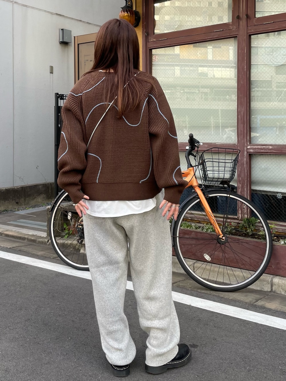 ブラウン系のニット/セーター、グレー系のその他パンツ、ホワイト系のTシャツ/カットソーを着用したレディースの冬コーディネートの4枚目の写真