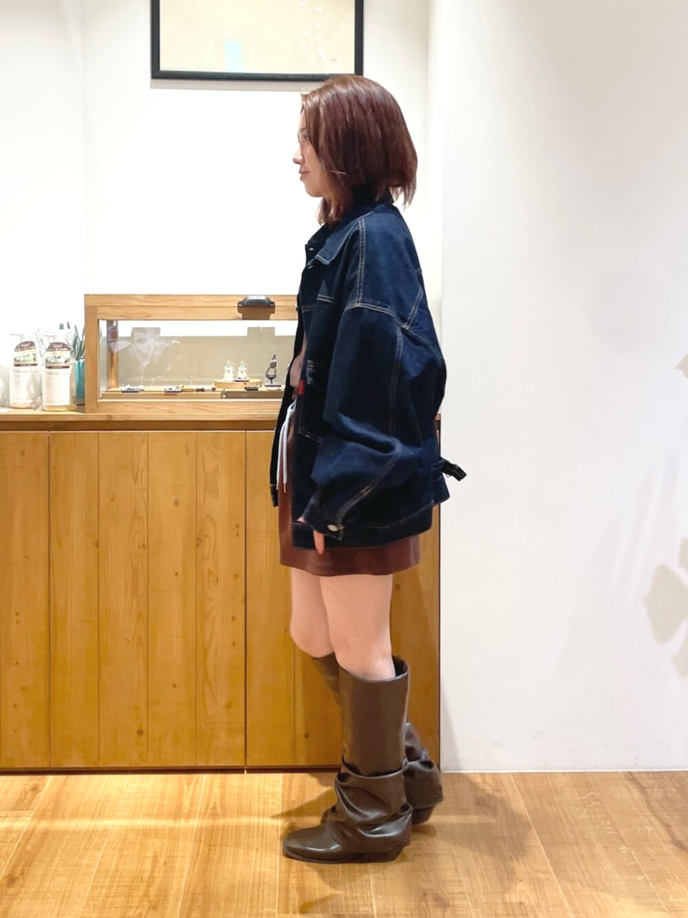 ブルー系のデニムジャケット、ブラウン系のタンクトップ、ブラウン系のスカートを着用したレディースの夏コーディネートの2枚目の写真