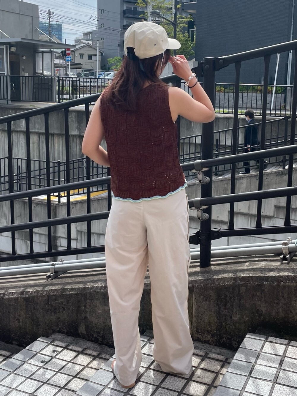 ブラウン系のニット/セーター、ホワイト系のその他パンツ、ブラック系のサンダルを着用したレディースの春コーディネートの3枚目の写真