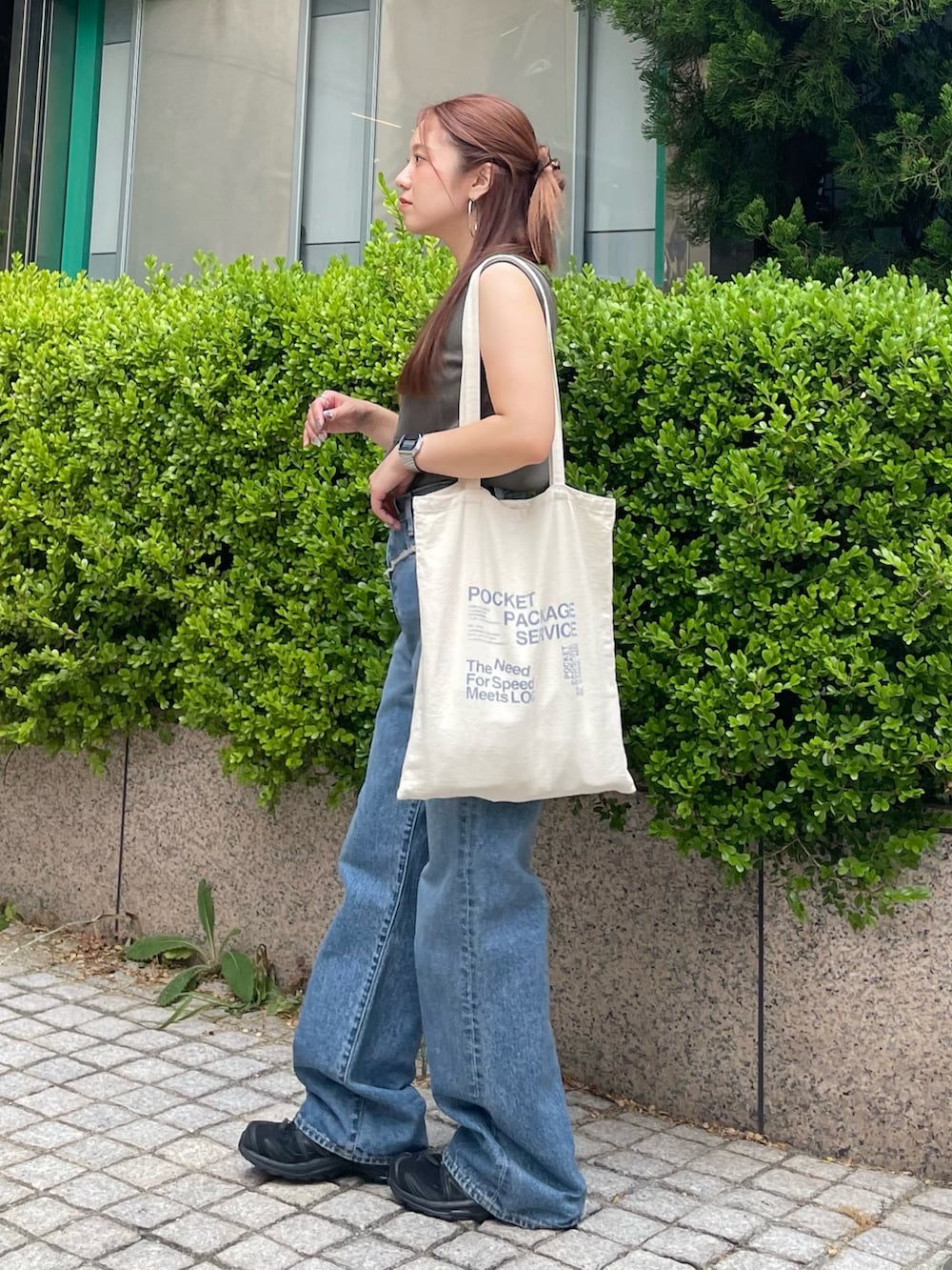 グレー系のタンクトップ、ブルー系のデニムパンツを着用したレディースの夏コーディネートの2枚目の写真
