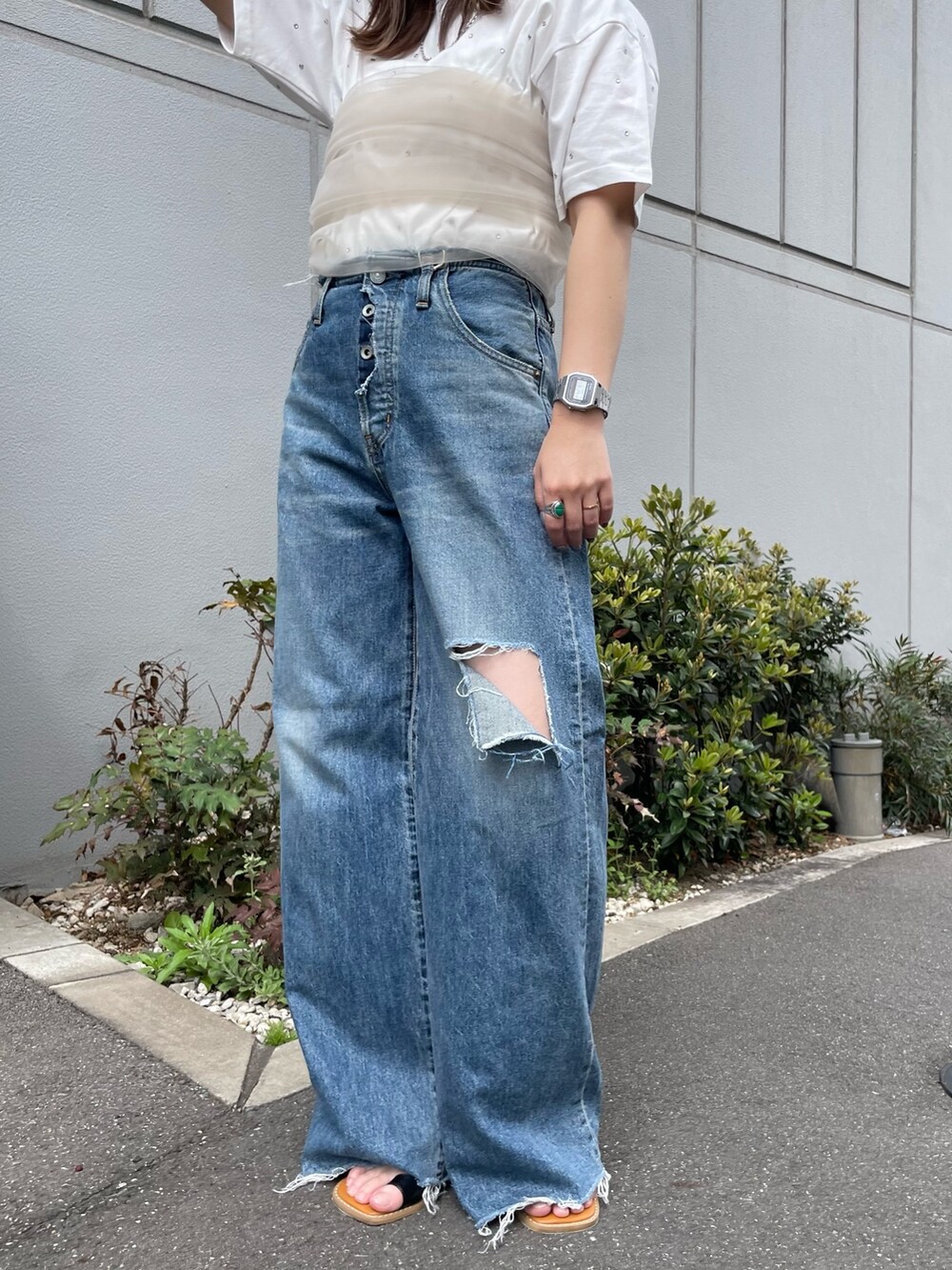 ホワイト系のTシャツ/カットソー、ベージュ系のキャミソール、ブルー系のデニムパンツを着用したレディースの春コーディネートの5枚目の写真
