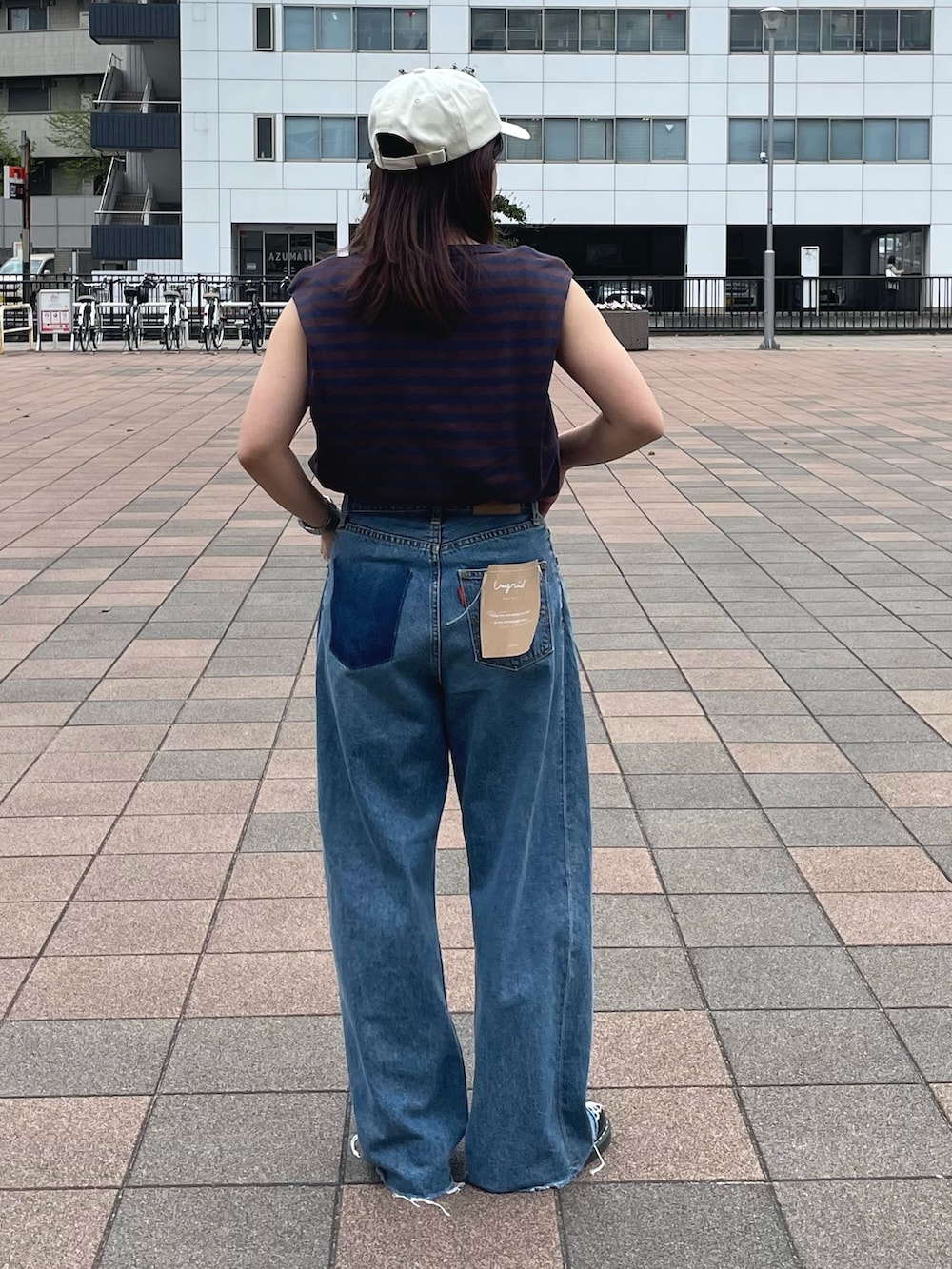 ブラウン系のTシャツ/カットソー、ブルー系のデニムパンツ、ホワイト系のキャップを着用したレディースの春コーディネートの3枚目の写真